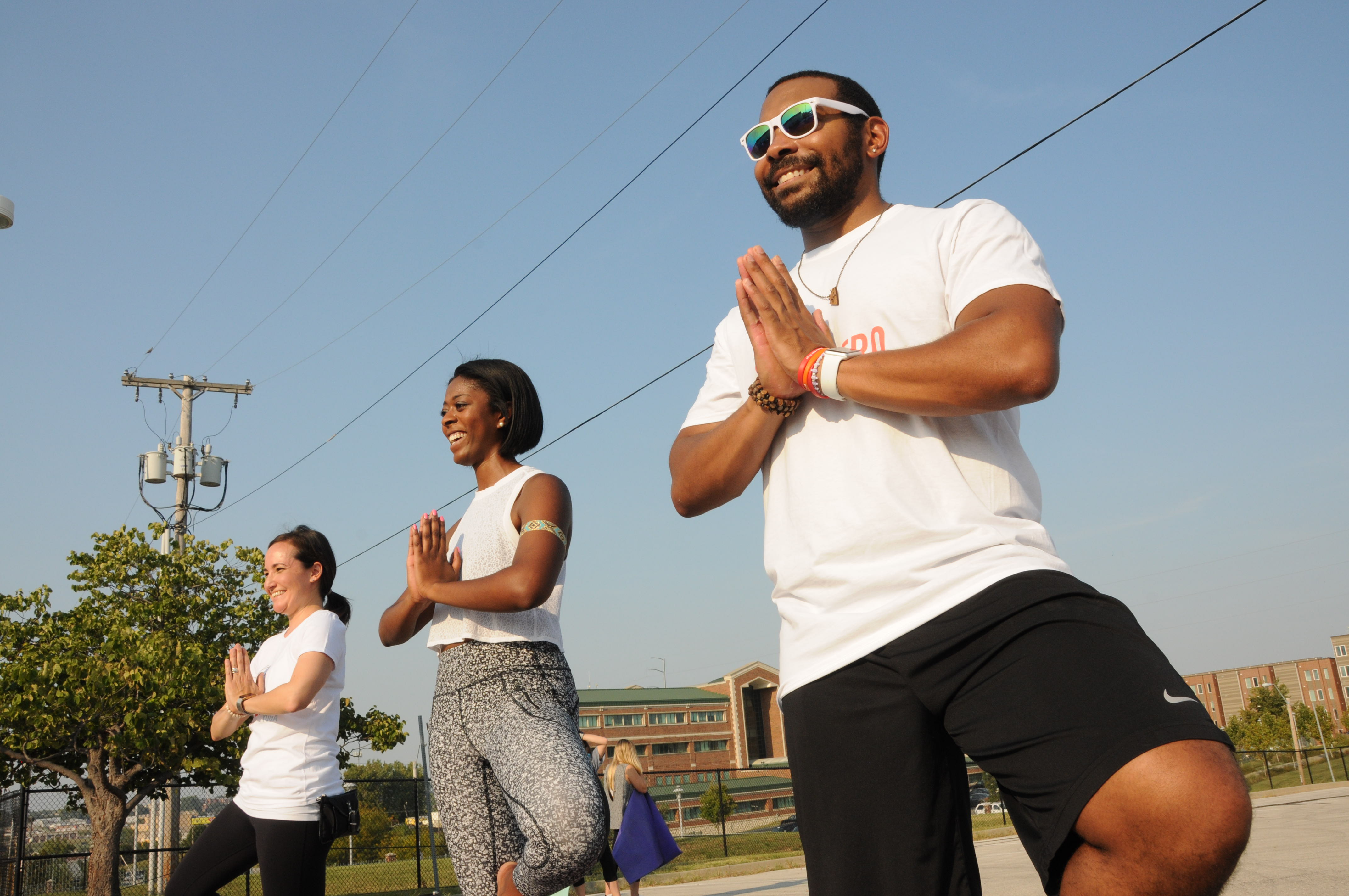 three med students pose during an outdoor yoga class.